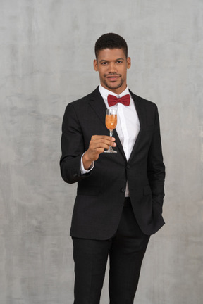 Well dressed man holding a champagne glass and looking at camera