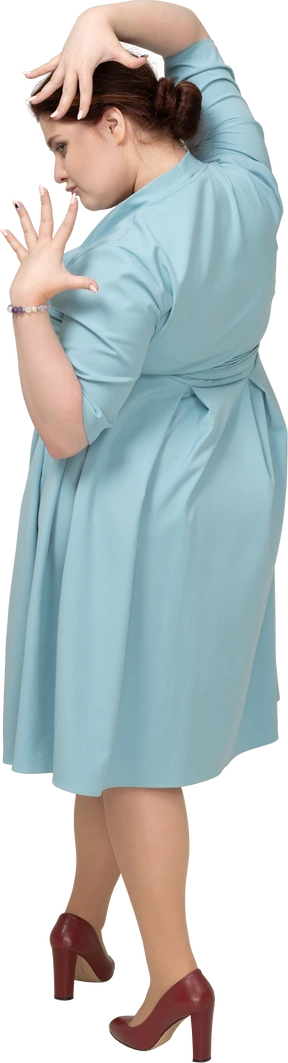 Rear view of a woman in blue dress posing