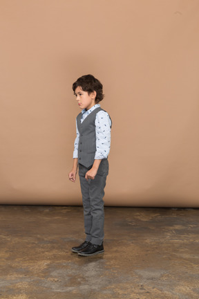 프로필에 서 있는 회색 양복에 귀여운 소년