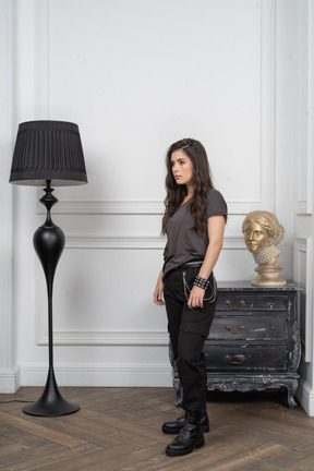 Side view of a young female rocker standing in a room