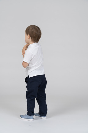 Little boy standing with his hands clasped