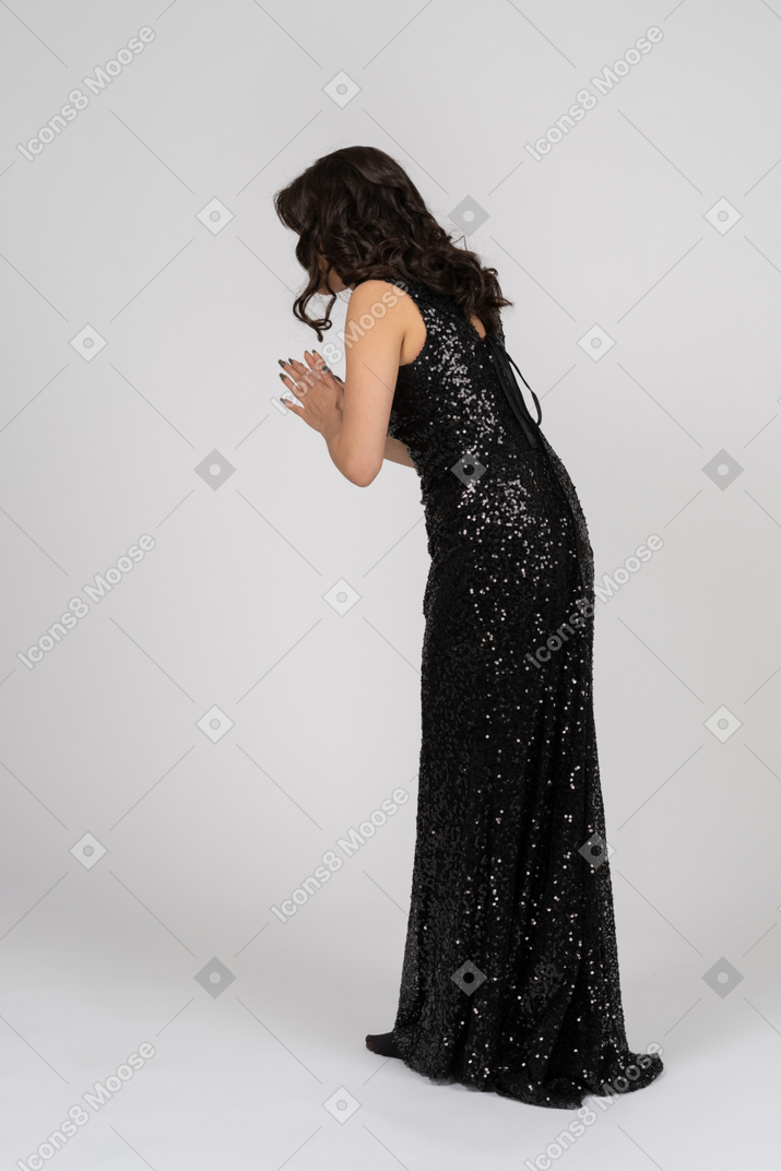 Praying woman wearing black evening dress