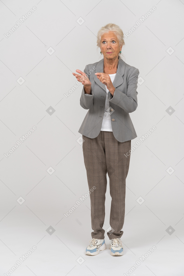 Vista frontale di una vecchia signora in giacca e cravatta che spiega qualcosa
