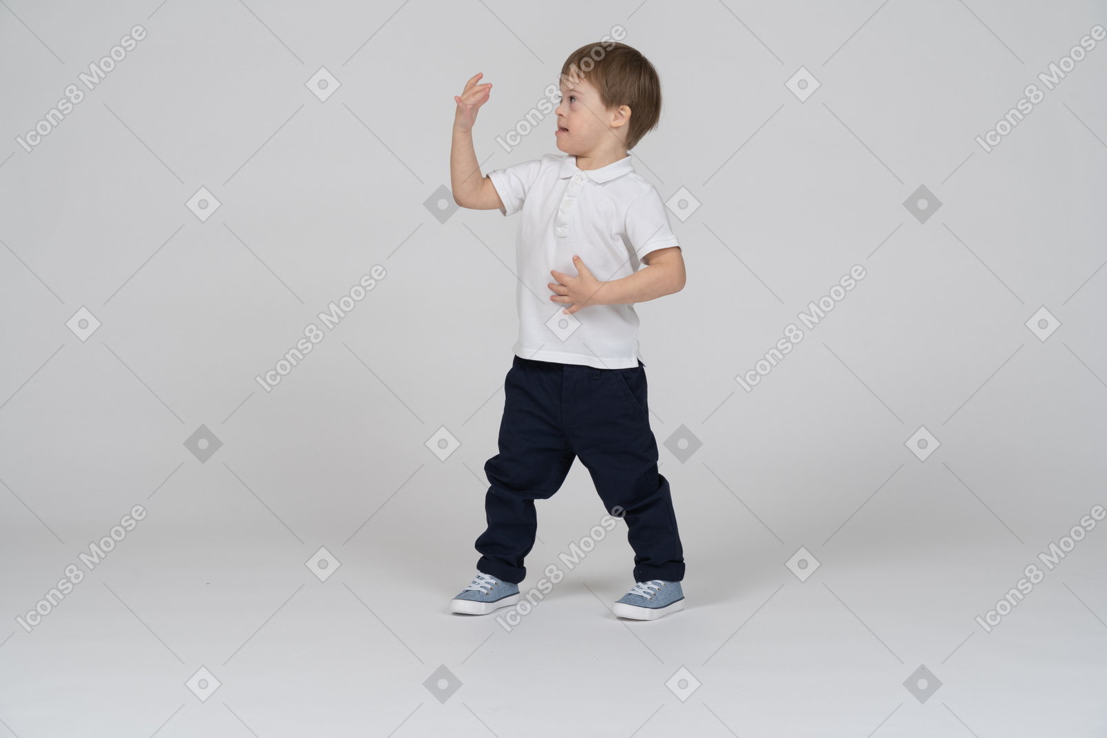 Niño pequeño de pie y mirando su mano
