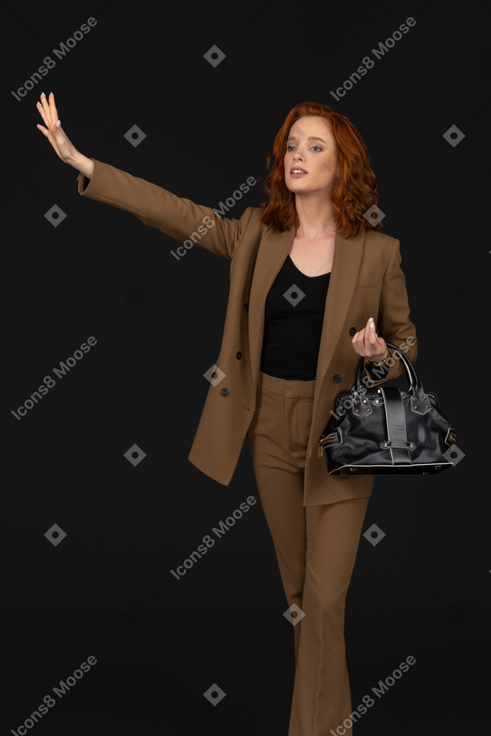 Front view of a businesswoman hailing a taxi