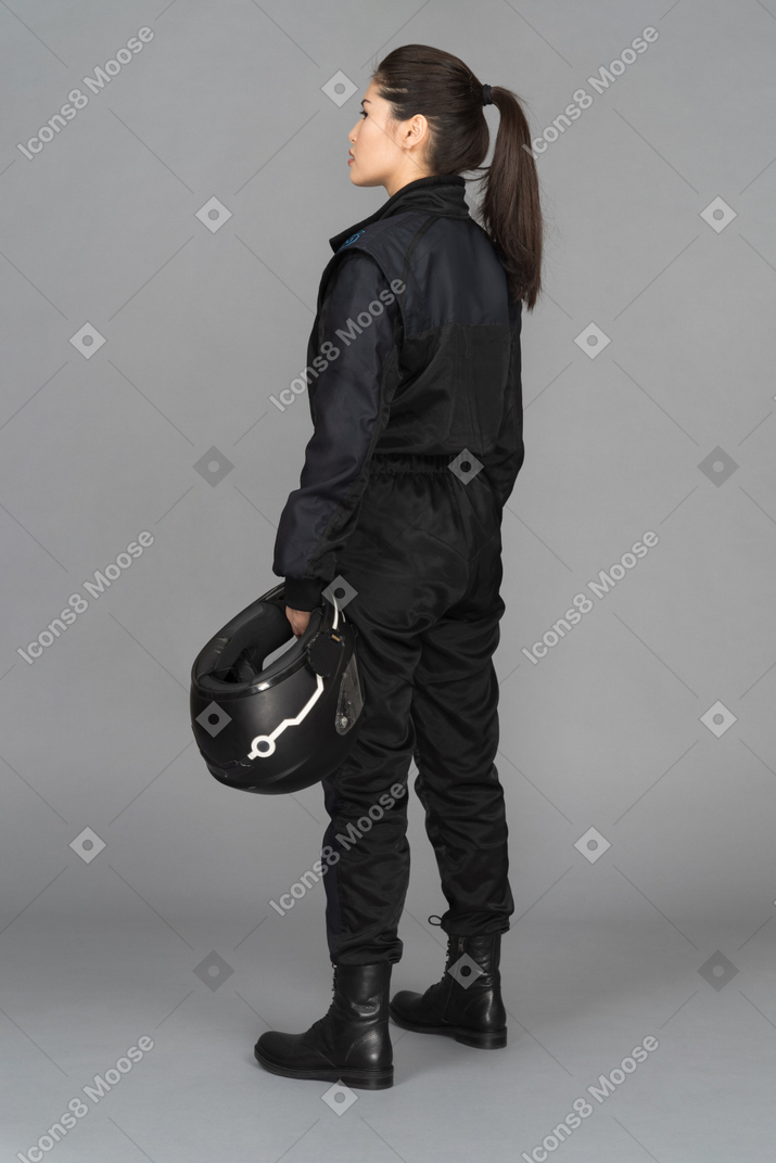 Young woman standing with a helmet in her hand