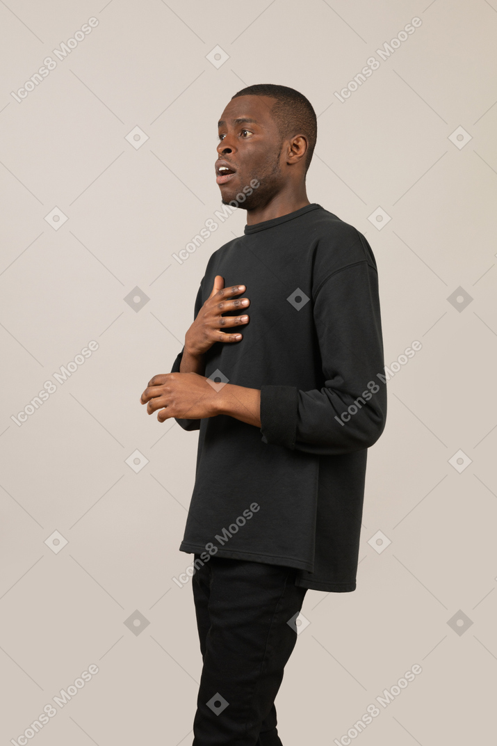 Scared young man with hand on chest