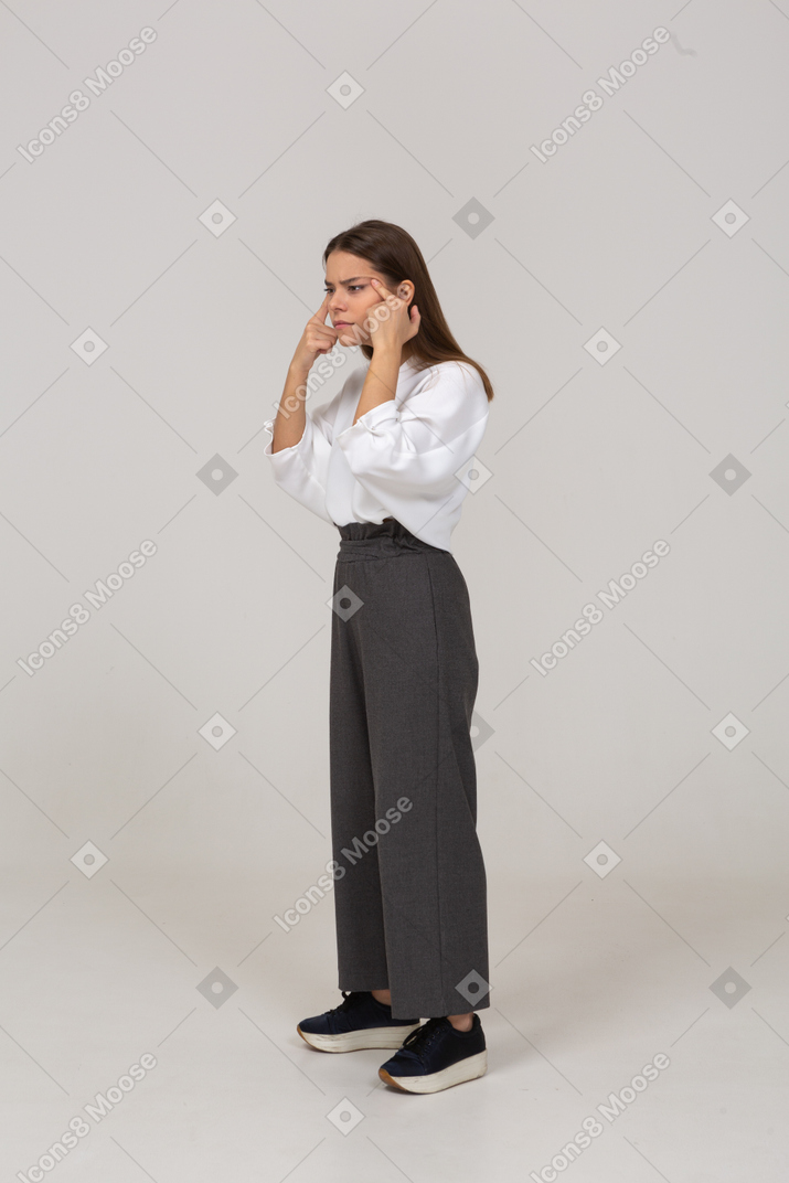 Vista de tres cuartos de una joven en ropa de oficina con mala vista