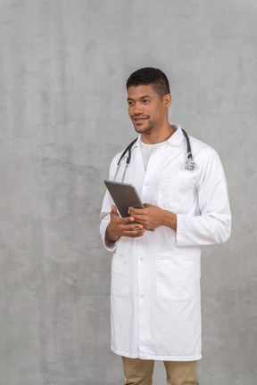 Smiling doctor with tablet talking to someone