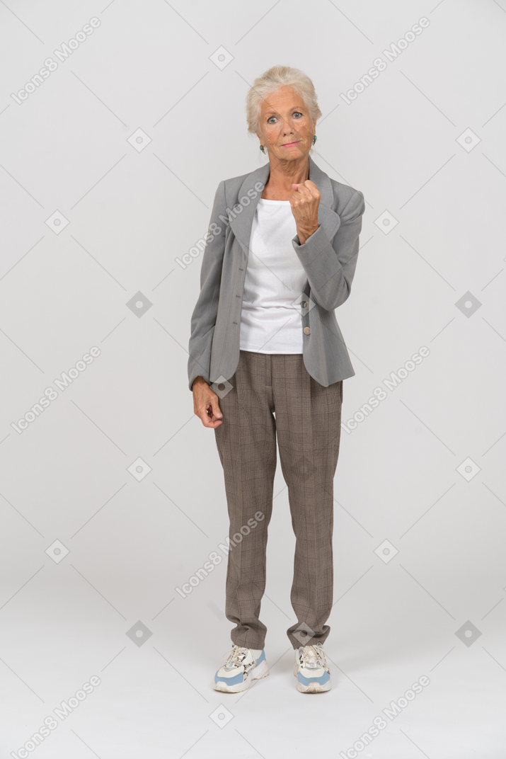 一位身穿西装、展示拳头的愤怒老太太的前视图
