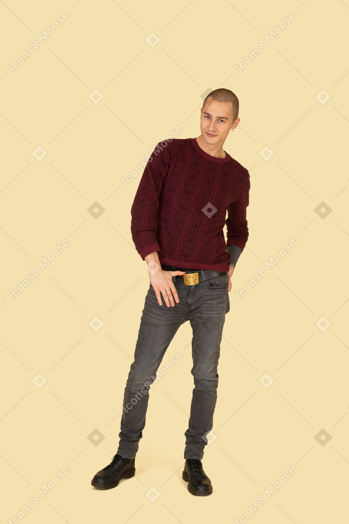 一个年轻人在触摸他的皮带的红色套衫的前视图