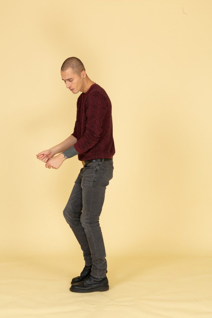 Side view of a dancing young man in red pullover