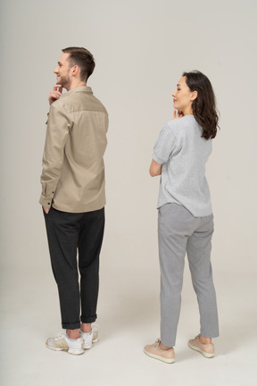 Three-quarter back view of young couple with hand on chin