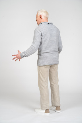 Rear view of a man standing with open hand