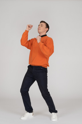 Young man in orange sweatshirt posing