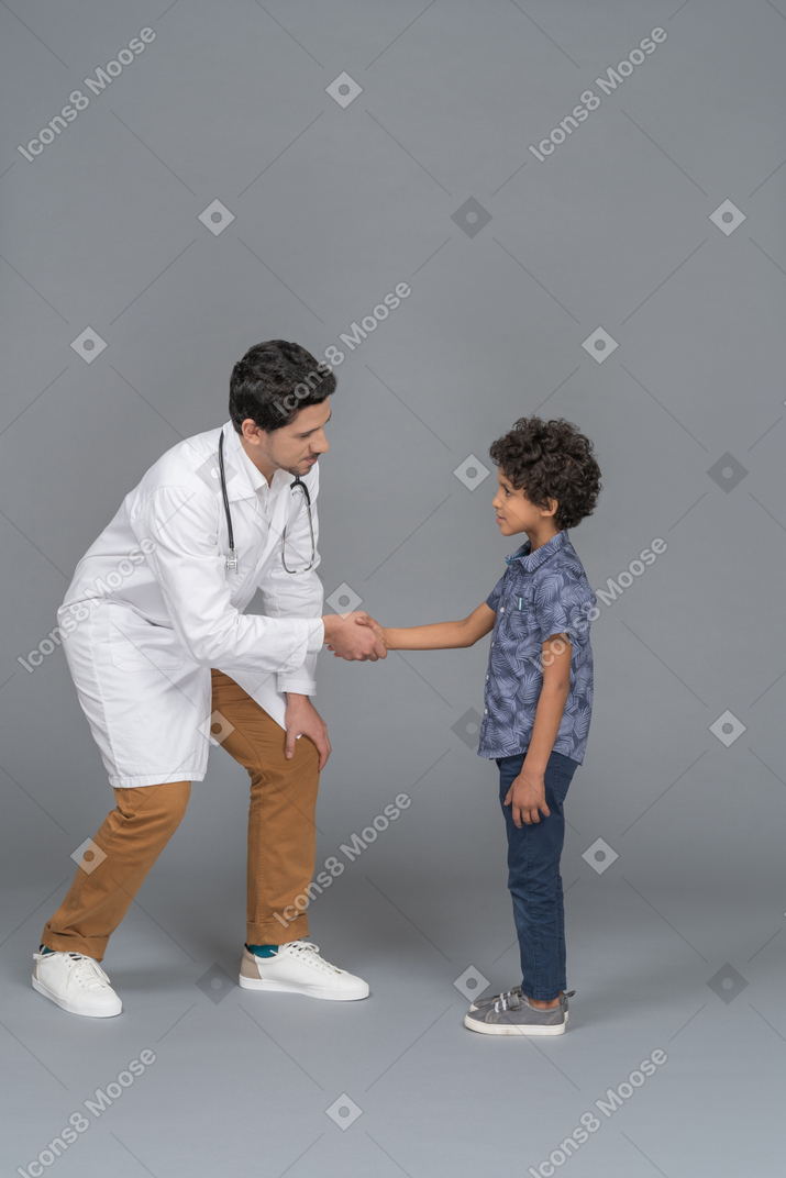 악수하는 작은 환자와 의사