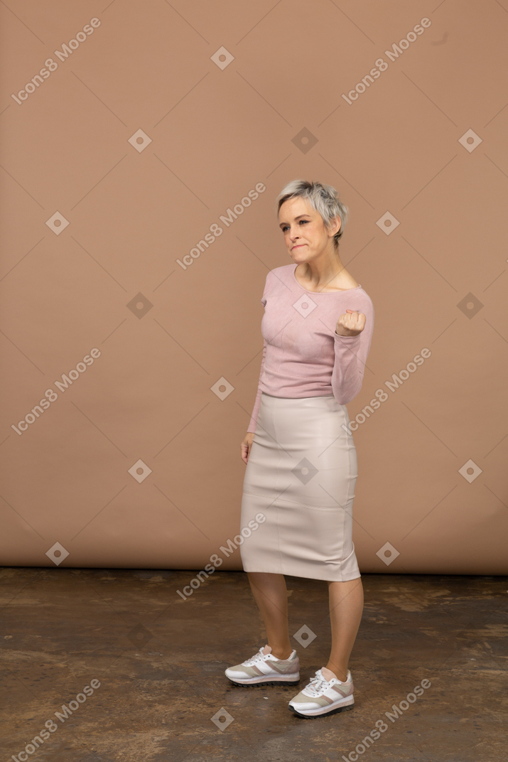 拳を示すカジュアルな服装で怒っている女性の側面図