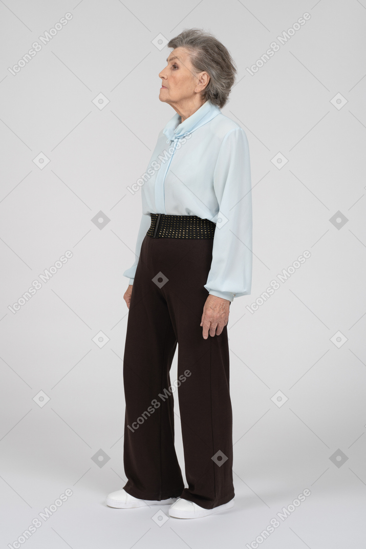 Three quarter view of old woman standing and looking straight