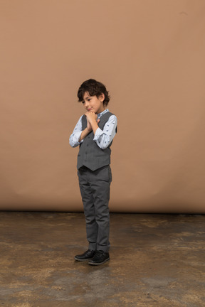 Vista frontal de un chico lindo en traje gris