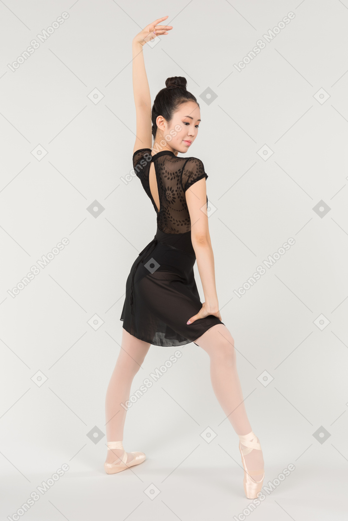 Young asian ballerina standing half sideways in position to camera