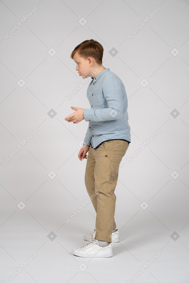 A little boy standing on a white surface