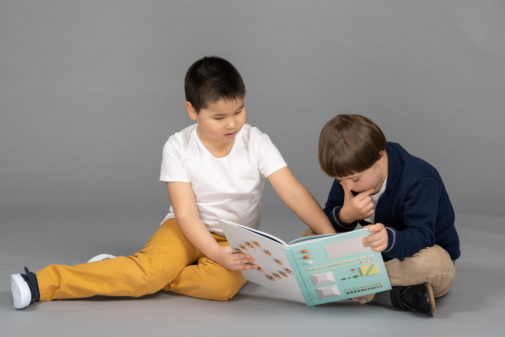 Two little boys looking at book illustrations