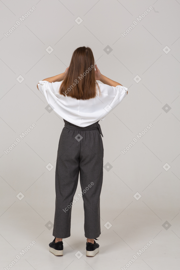 Back view of a young lady in office clothing hiding her mouth