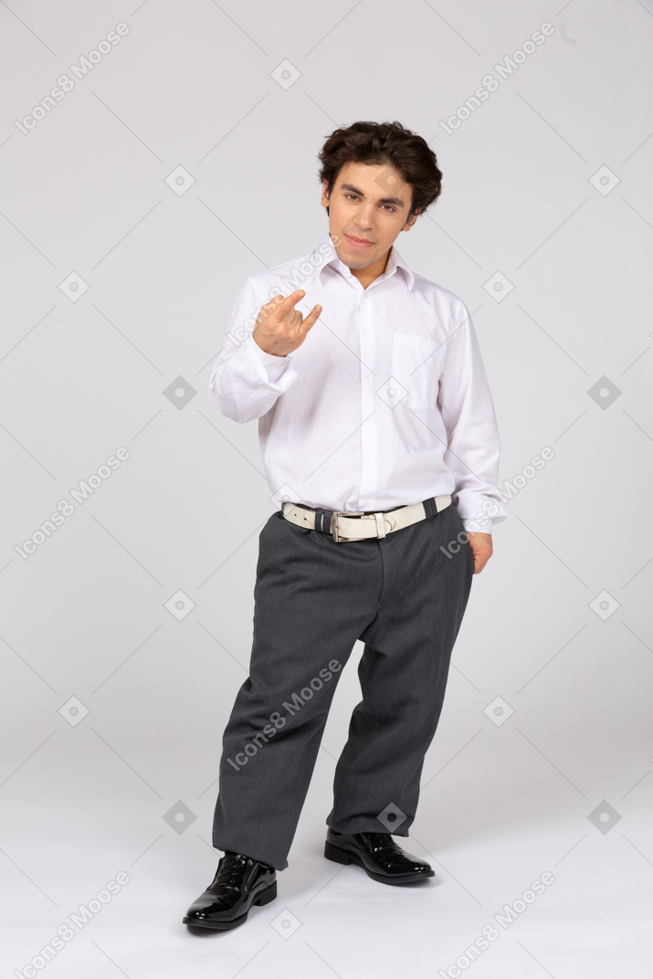 Man in business casual clothes showing rock hand gesture