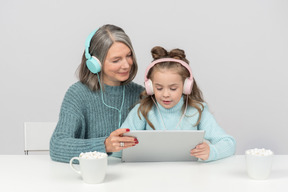 祖母和孙女一起使用数字平板电脑
