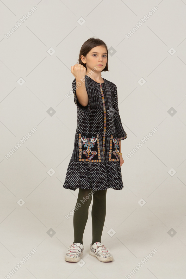 Front view of a little girl in dress clenching fist