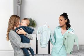 Женщина с ребенком покупает одежду