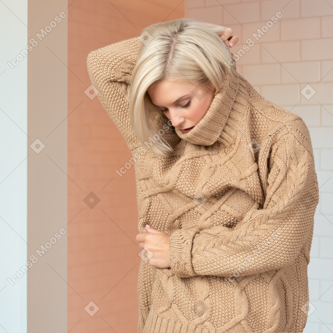 A woman wearing a camel cable knit sweater