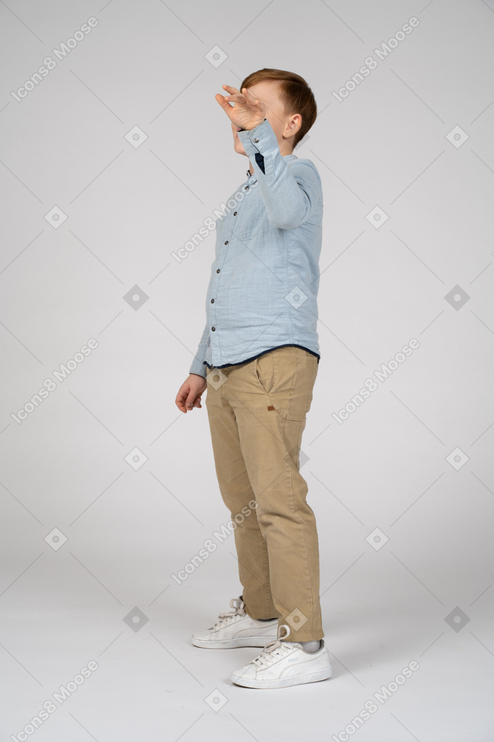 Boy in pants and shirt lifting his arm
