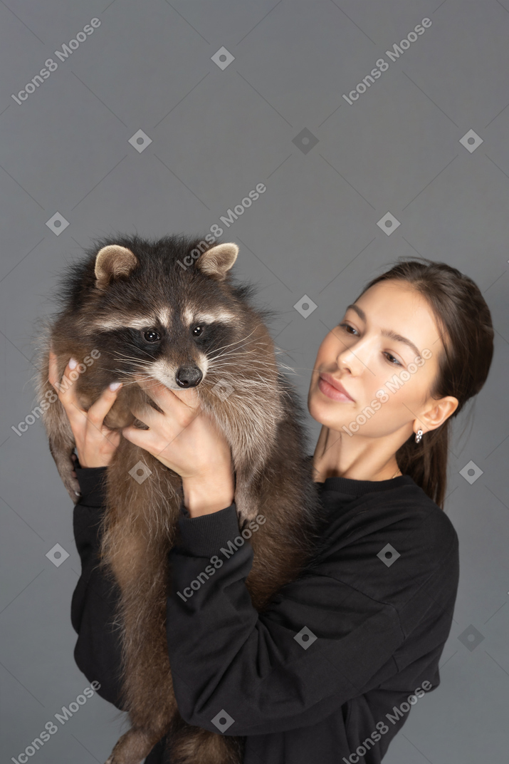 Pretty woman holding a raccoon