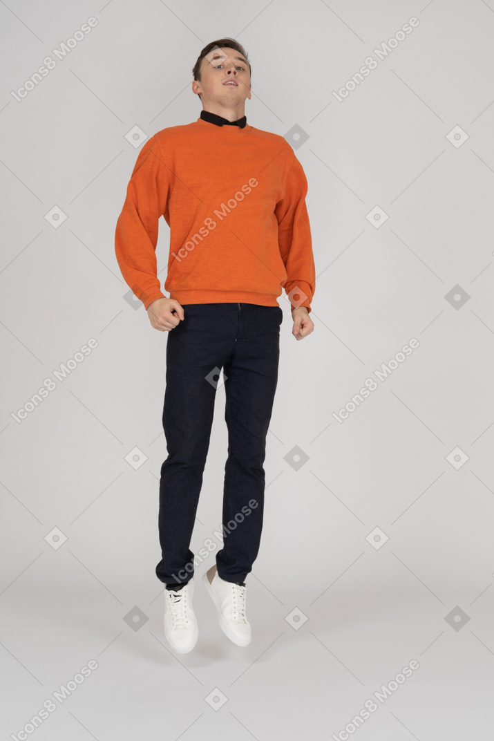 Junger mann im orangefarbenen sweatshirt stehend