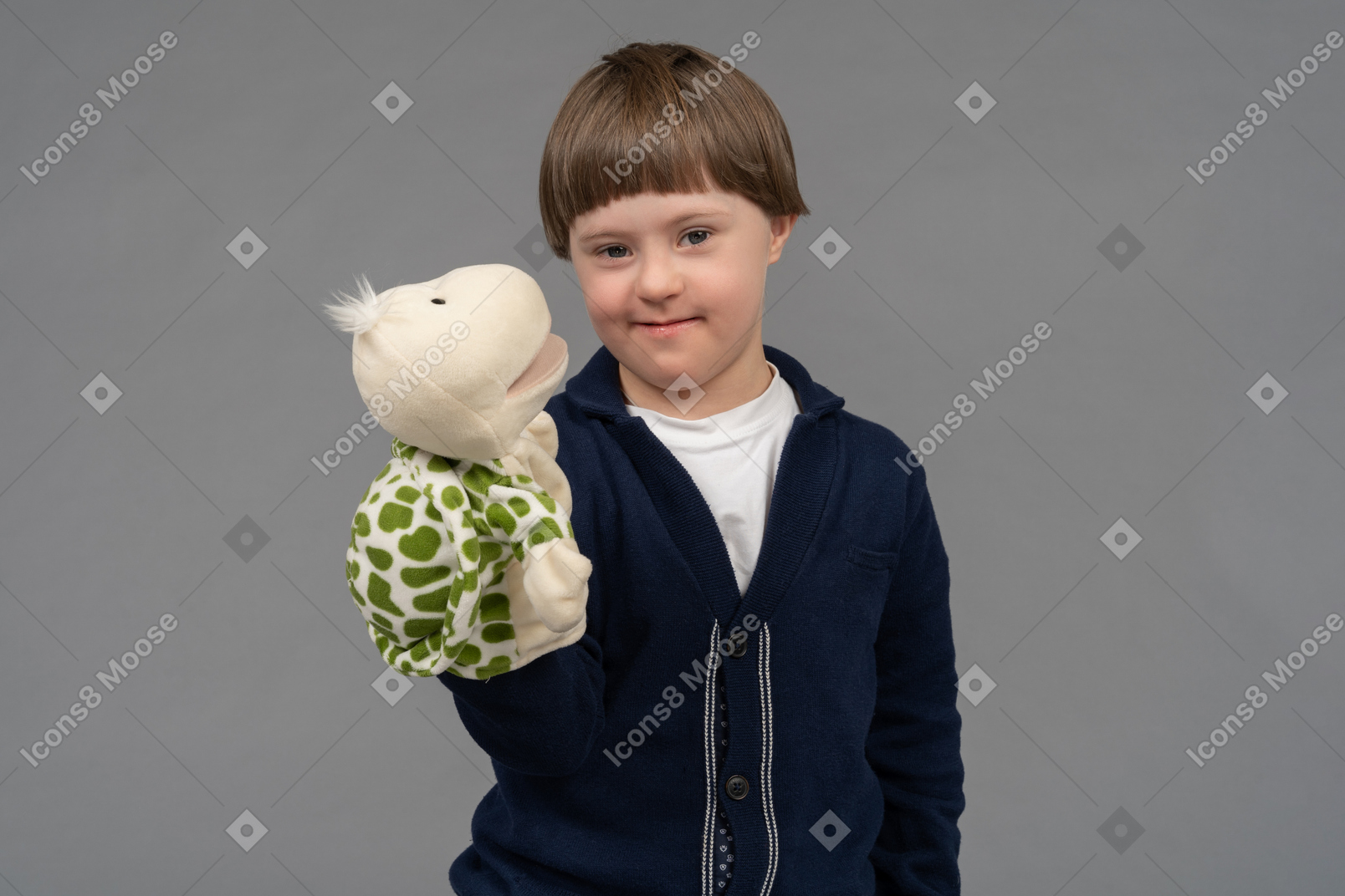 Portrait of a little boy holding a tortoise puppet