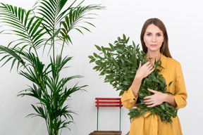 Woman in a yellow shirt holding a bouquet of branches