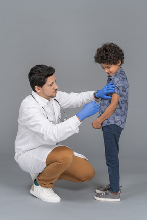 Menino e médico após vacinação