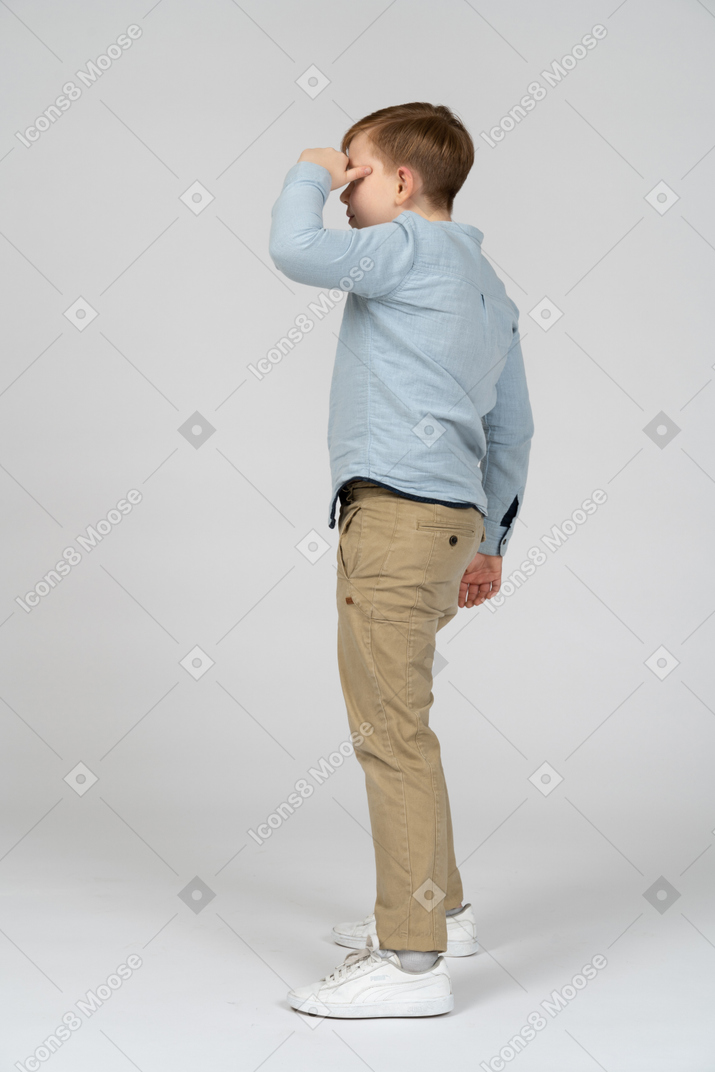 Side view of boy covering his eyes