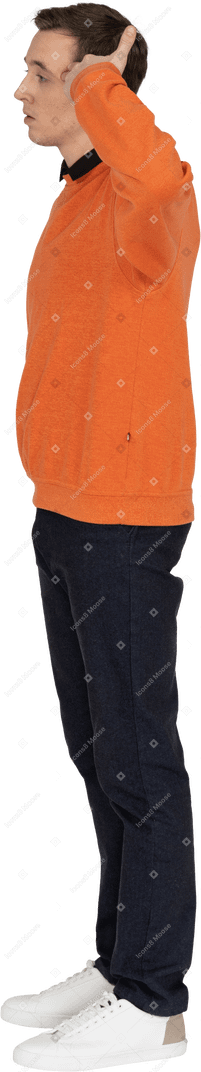 Junger mann im orangefarbenen sweatshirt stehend