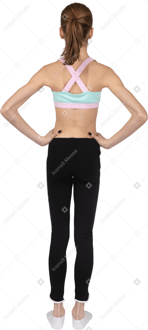 Вид сзади девушки-подростка в спортивной одежде, кладущей руки на бедра