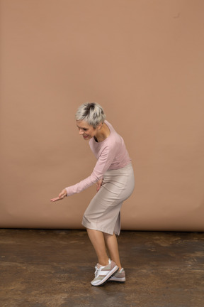 Vista lateral de una mujer en ropa casual haciendo gesto de bienvenida