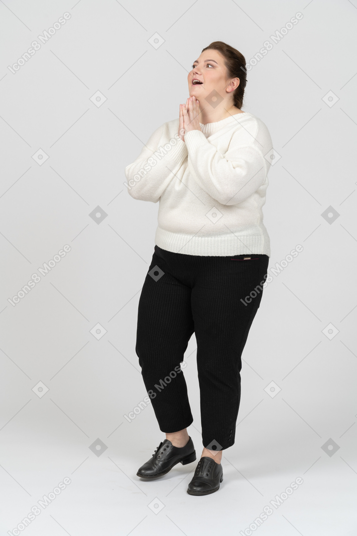 Удивленная пухлая женщина в белом свитере