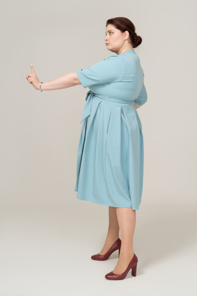 Vista laterale di una donna in abito blu che gesticola