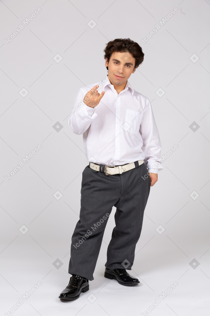 Homem com roupa formal, mostrando o gesto com a mão do rock
