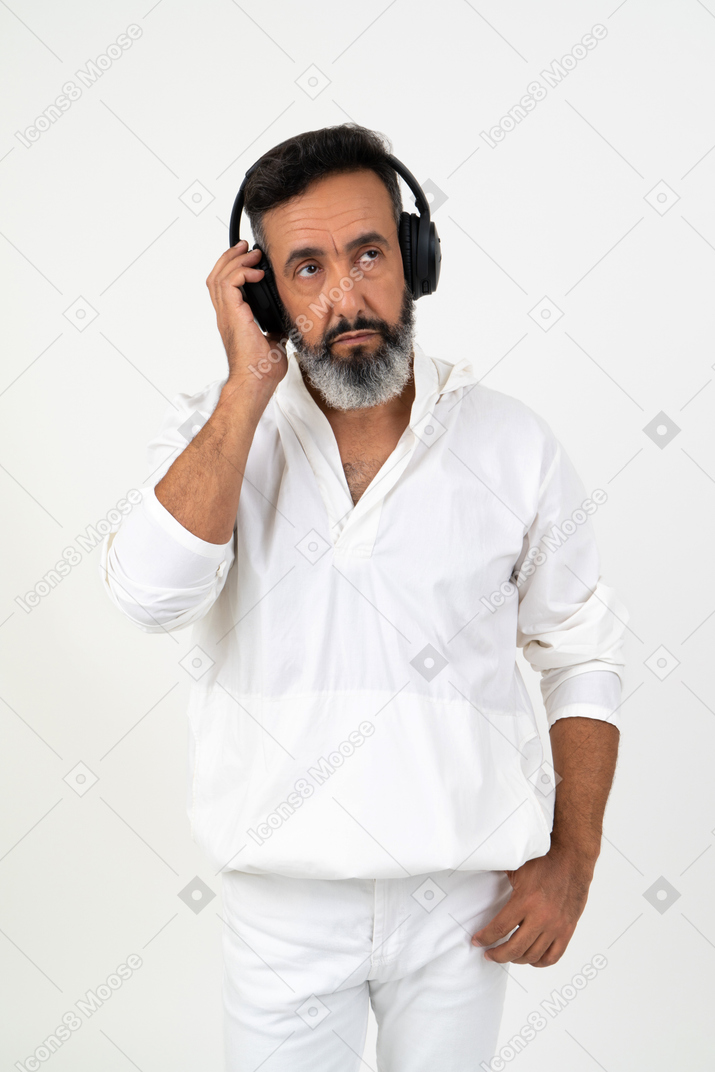 Mature man involved in his thoughts  listening to music