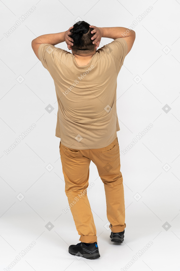 Plump man holding head with both hands back to camera