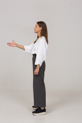 Vista lateral de una joven en ropa de oficina que muestra la dirección correcta