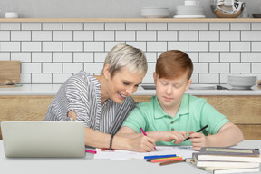 Grand-mère aidant son petit-fils à faire ses devoirs