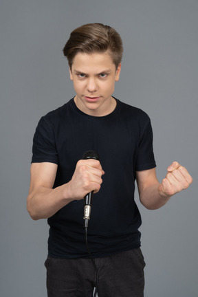 Aggressive young man gesturing and holding microphone